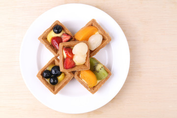 Assorted fruit tarts on round plate