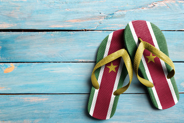 Thongs with flag of Suriname, on blue wooden boards