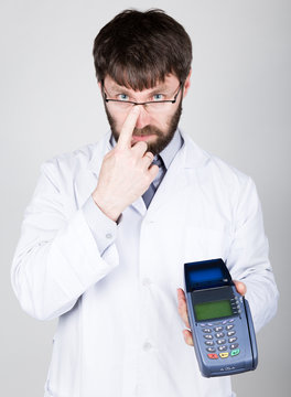 close-up portrait of a medical doctor, he proposes to pay for treatment in pos-terminal. concept of high cost of the treatment 