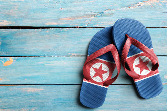 Thongs with flag of North Korea, on blue wooden boards