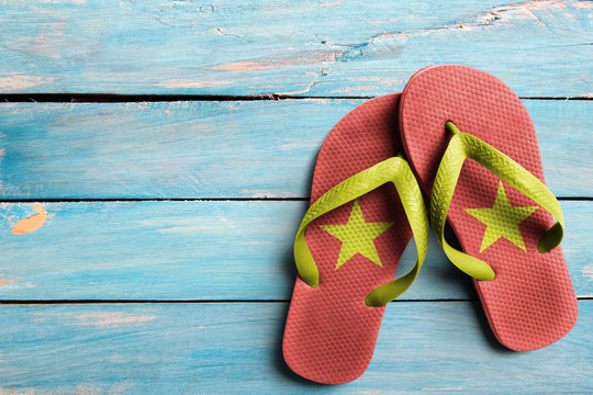 Thongs with flag of Vietnam, on blue wooden boards
