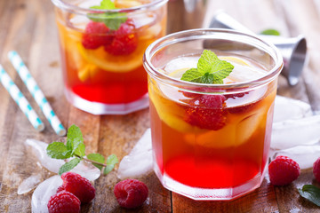 Red summer cocktail with lemons and raspberry
