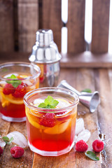 Red summer cocktail with lemons and raspberry