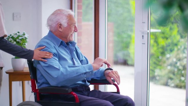 Caring young home support worker with elderly gentleman in his home