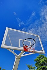 Basketball hoop with sky and sun