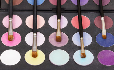 Palette eye shadow and cosmetic brushes for makeup.