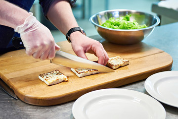 Preparing dishes of fried cheese and green salad