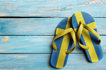 Thongs with flag of Sweden, on blue wooden boards