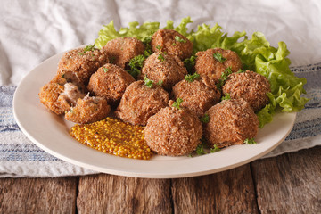 Tasty meat balls Bitterballen and mustard close up on a plate. horizontal
