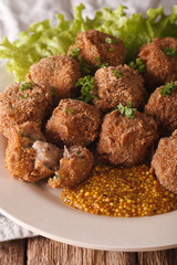 Dutch meat balls with mustard Bitterballen close-up on a plate. Vertical
