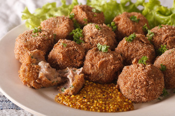 Dutch meat balls with mustard Bitterballen close-up on a plate. horizontal
