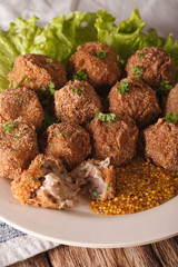 Bitterballen veal with mustard on a plate close-up. vertical
