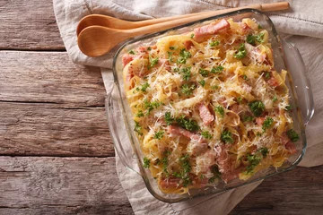Photo sur Plexiglas Plats de repas noodles baked with ham and cheese close-up in a baking dish. horizontal top view   