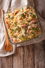 noodles baked with ham and cheese close-up in a baking dish. vertical top view 
