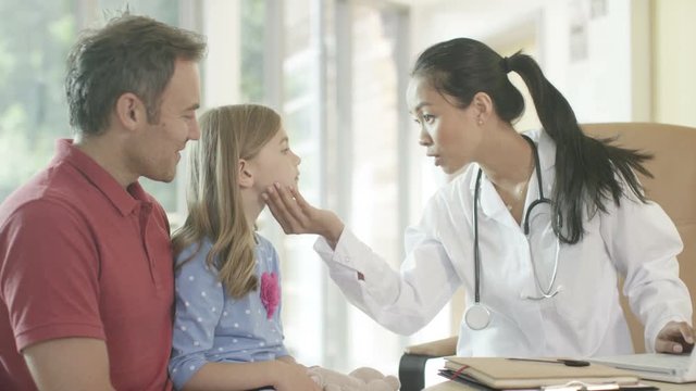  Friendly doctor talking to parent and child patient in office