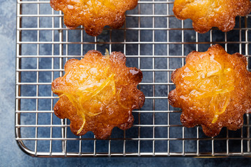Lemon muffins cakes, financiers on a cooling rack Blue stone background