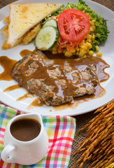 Beef steak with black pepper sauce , salad and French fries on s
