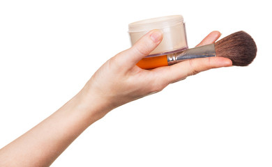 Female hand holding  cosmetic brush and face powder  on white .
