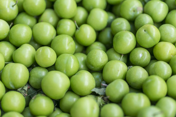 Unripe Plums on a market
