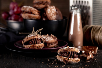 Maroni cookies and chocolate milkshakes on dark wooden backgroun