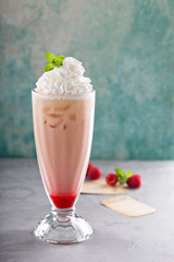 Iced milkshake with raspberry syrup and whipped cream