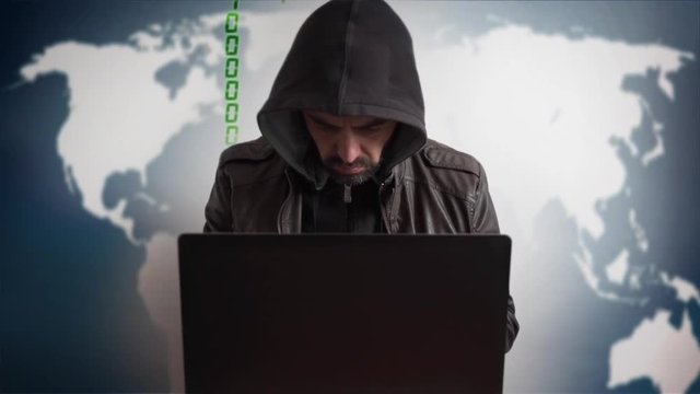 Bearded hacker in a hood with laptop. Online world network danger.