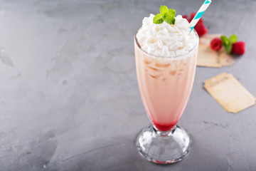 Iced milkshake with raspberry syrup and whipped cream
