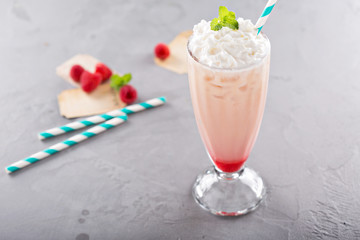 Iced milkshake with raspberry syrup and whipped cream
