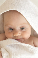 Cute baby girl covered with a thick towel