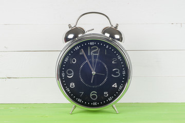 Retro alarm clock on table on mint green background