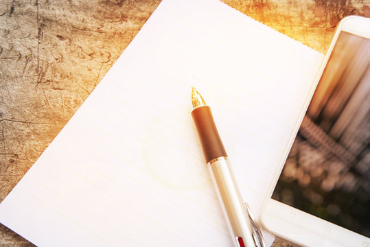 Pen and Notepad on the wooden desk