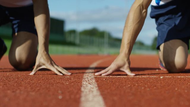  Low angle view, 2 unrecognisable athletes at running track