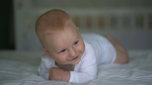 cute baby laughing lying on the bed