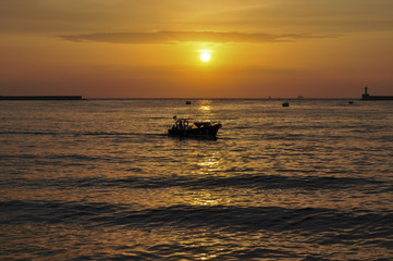 Silhouette of boats at sunset background