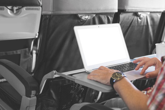 man working on laptop in aircraft cabin