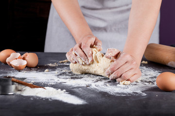 Baker is making  cookies with wooden rolling pin, flour, cinnamo