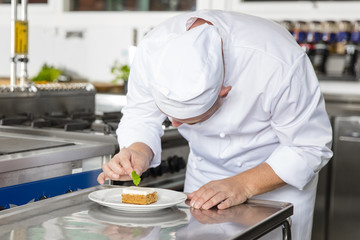 Obraz na płótnie Canvas Professional chef decorate dessert cake with lemon leaf