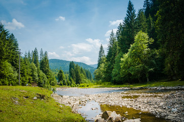 The river flows between green mountains