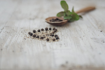Heart made of peppercorns with mint and wooden spoon