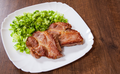 meat fillet steak with vegetables salad in a plate on wooden table