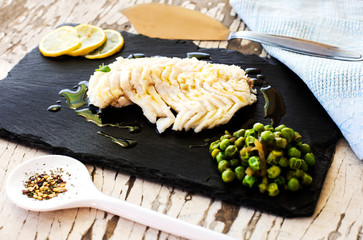 spicy cod fillet with steamed peas over slate