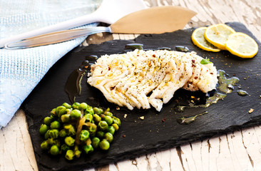 spicy cod fillet with steamed peas over slate