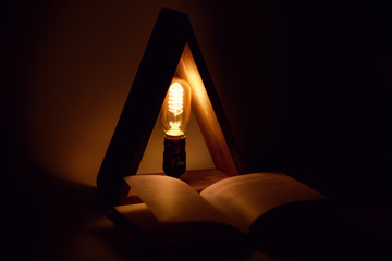 Night edison eco lamp with filament covers book for reading.