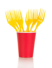 Bright disposable cups and plastic forks isolated on white .