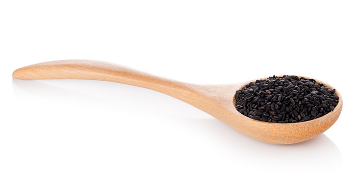 Black Sesame seeds in wood spoon on white background
