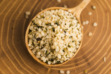 Shelled hemp seeds on wood background