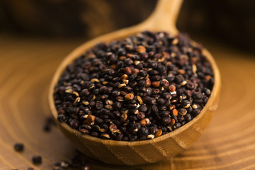 Black quinoa seeds on a wooden background