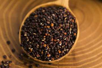 Black quinoa seeds on a wooden background