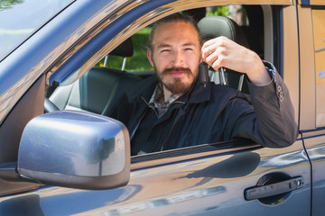 Smiling man with keys as a driver of modern car