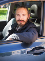 Positive Asian man as a driver of modern car